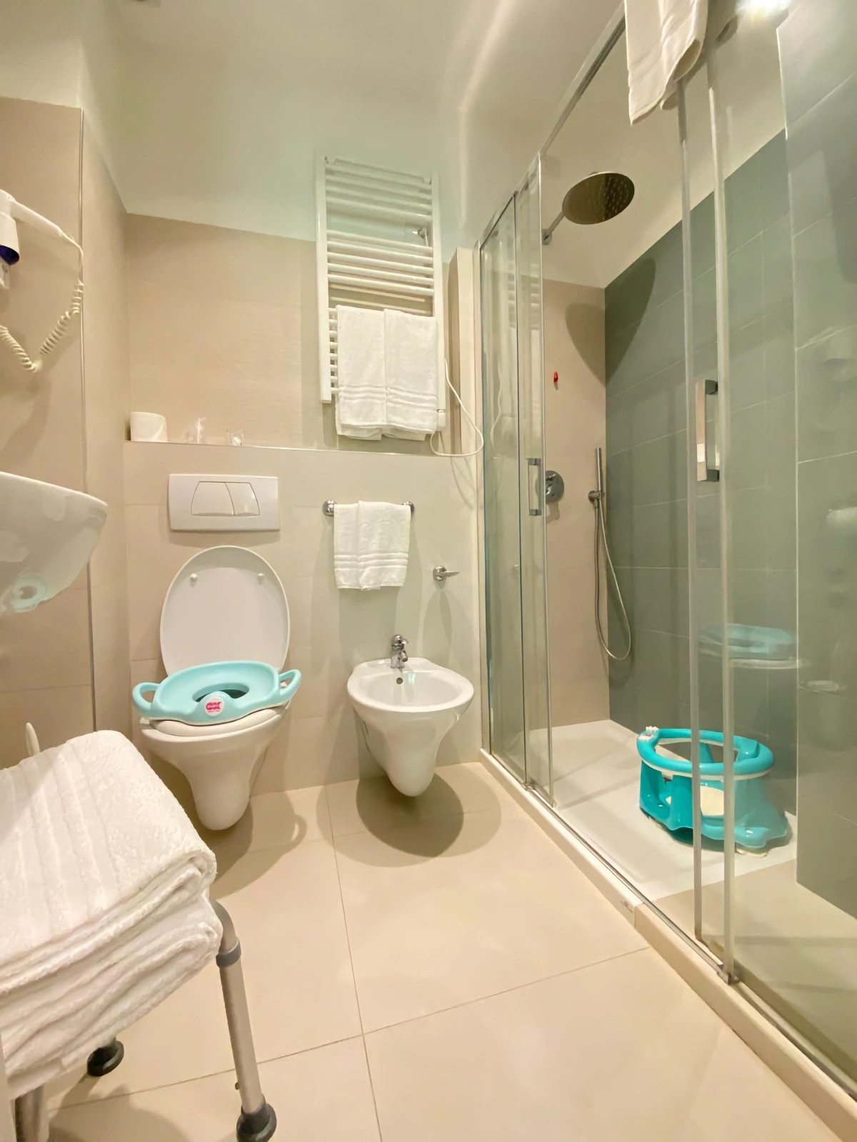 Bagno con doccia, asciugamani e bagnetto doccia per bambini